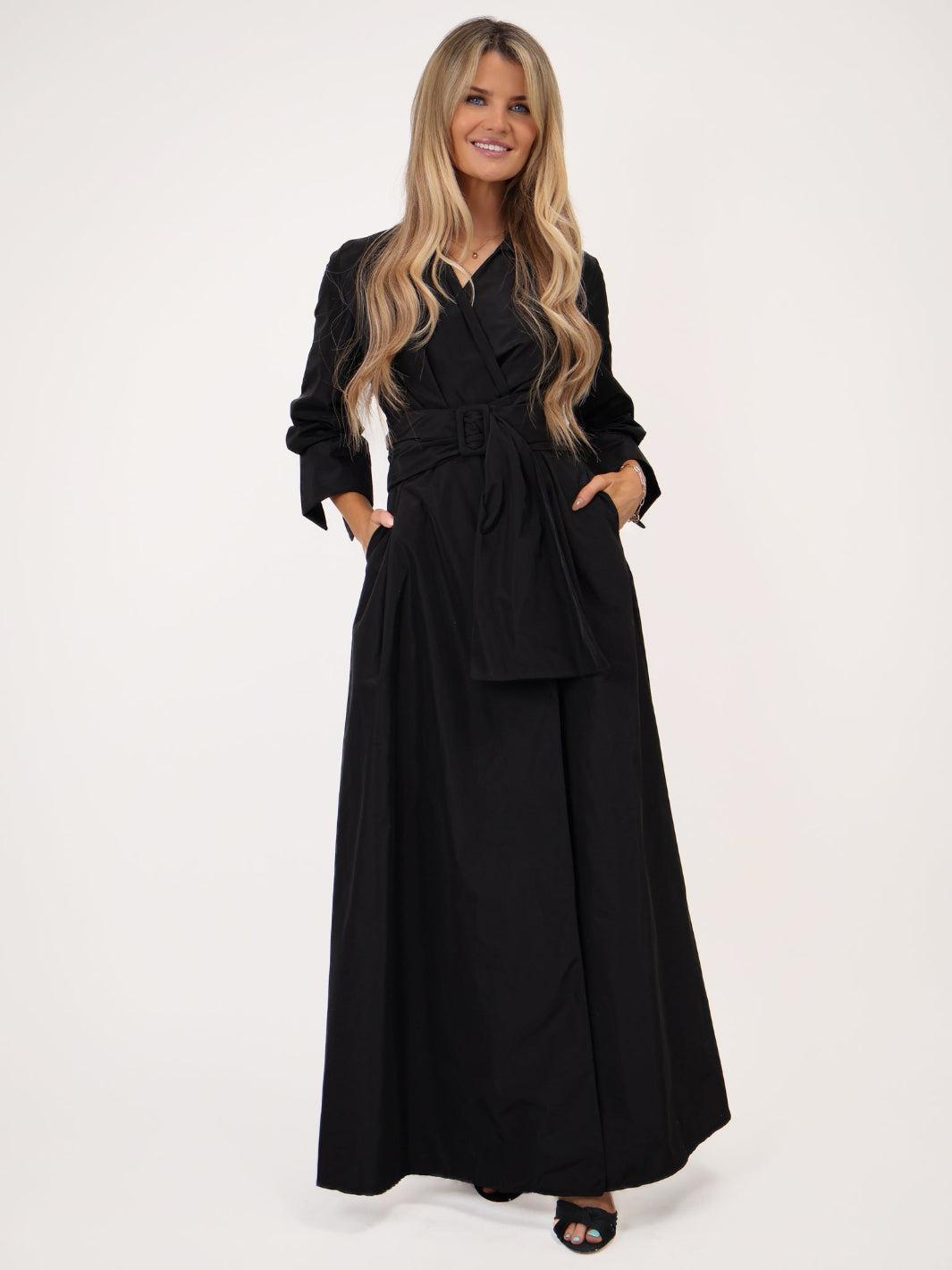 Woman wearing a black dress with a belt on a white background