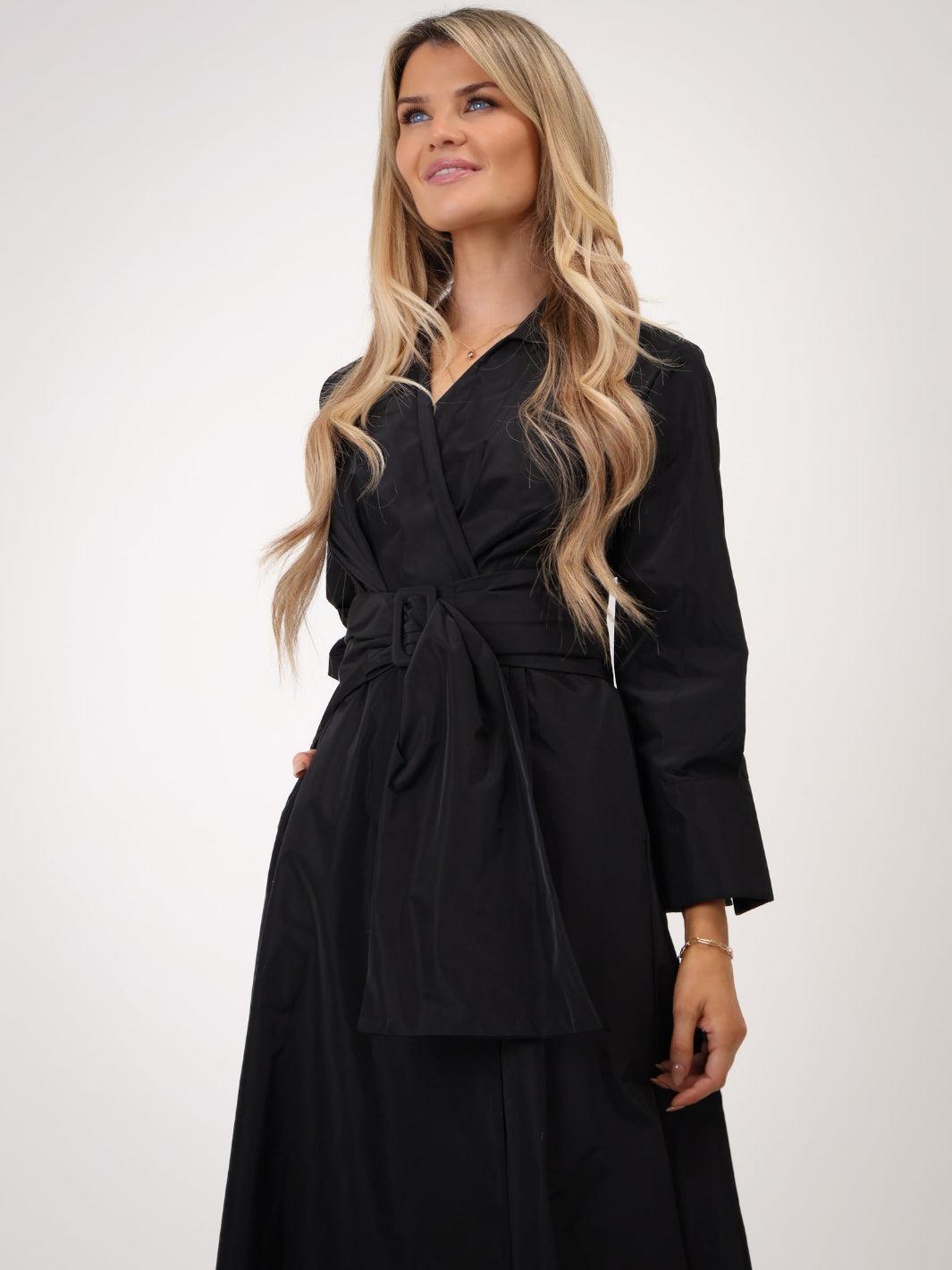 Woman wearing a black dress with a belt on a white background