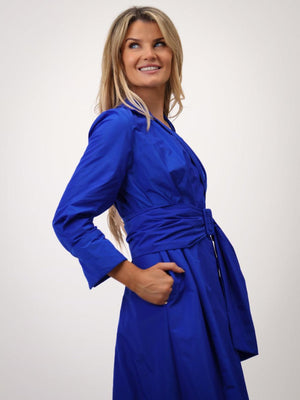Woman wearing a blue dress against a white background