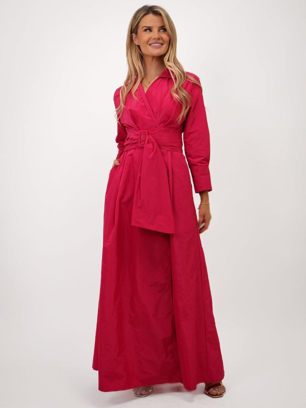Woman wearing a pink dress with a belt on a white background
