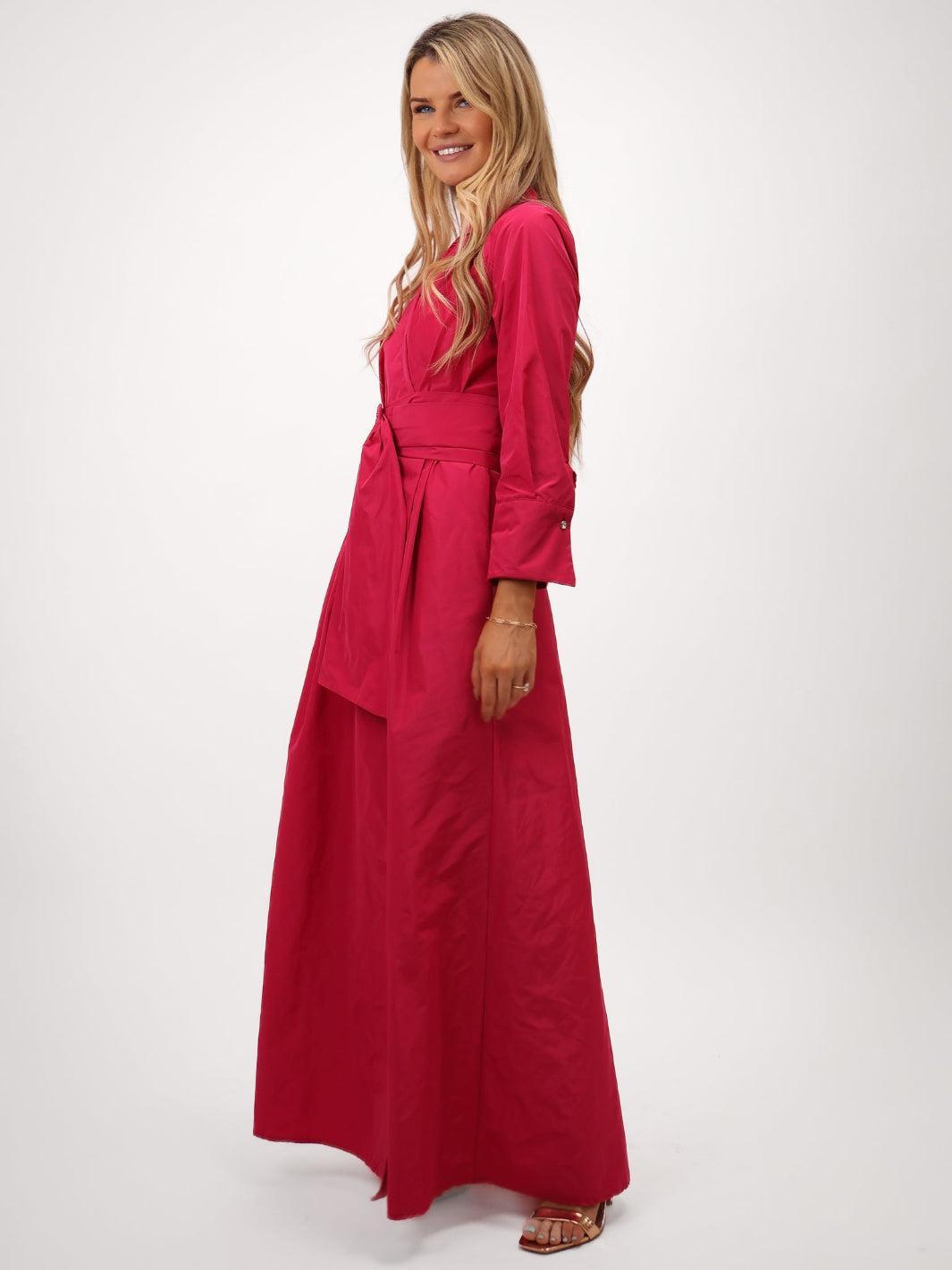 Woman wearing a long red dress on a white background
