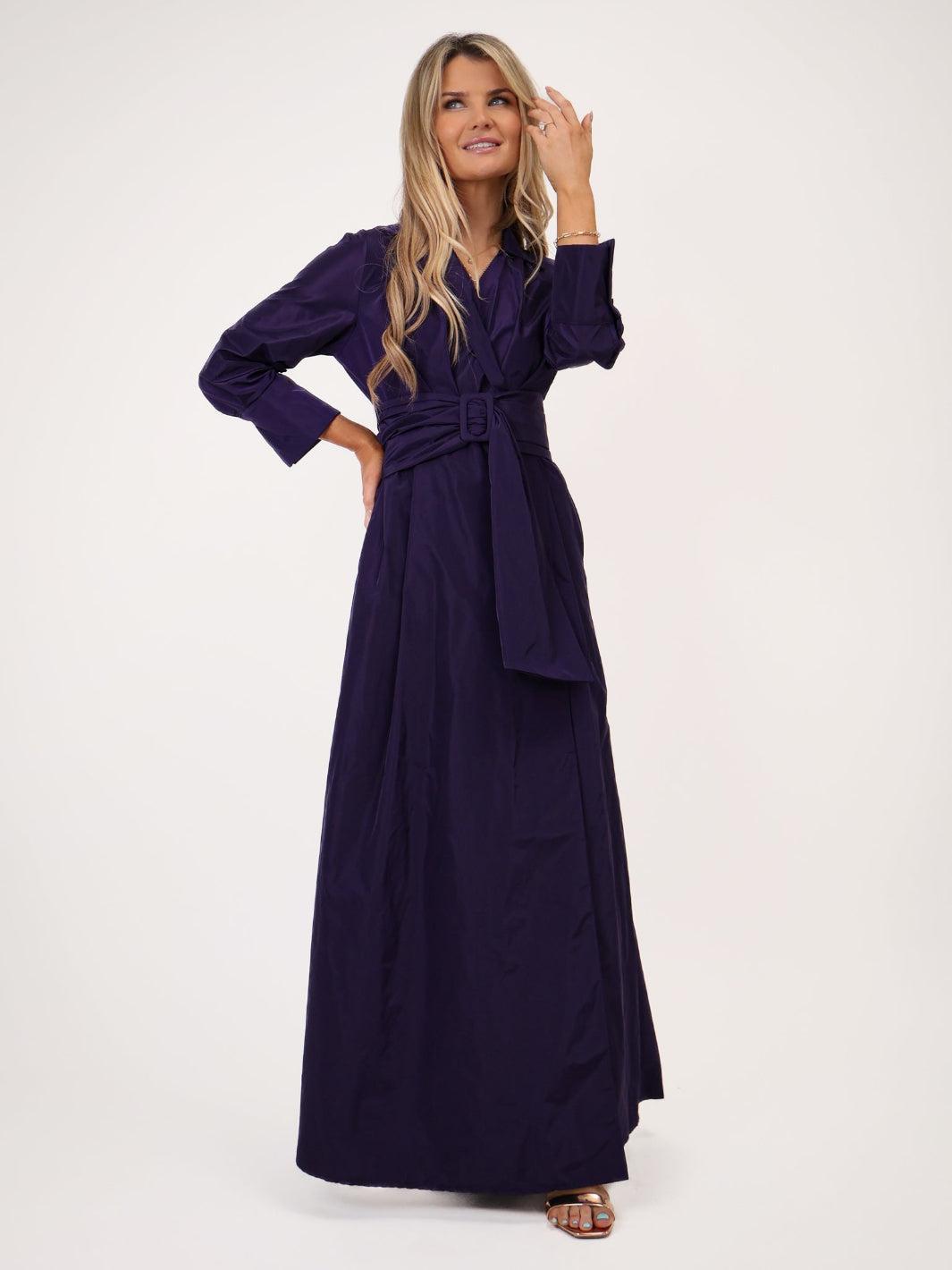 Woman wearing a long purple dress on a white background