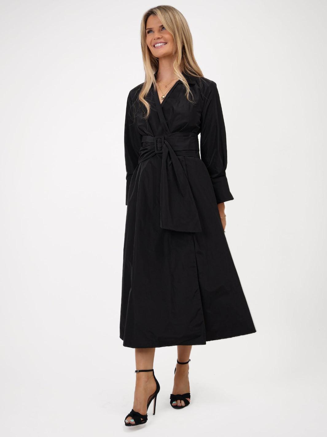 Woman wearing a black dress with a belt on a white background