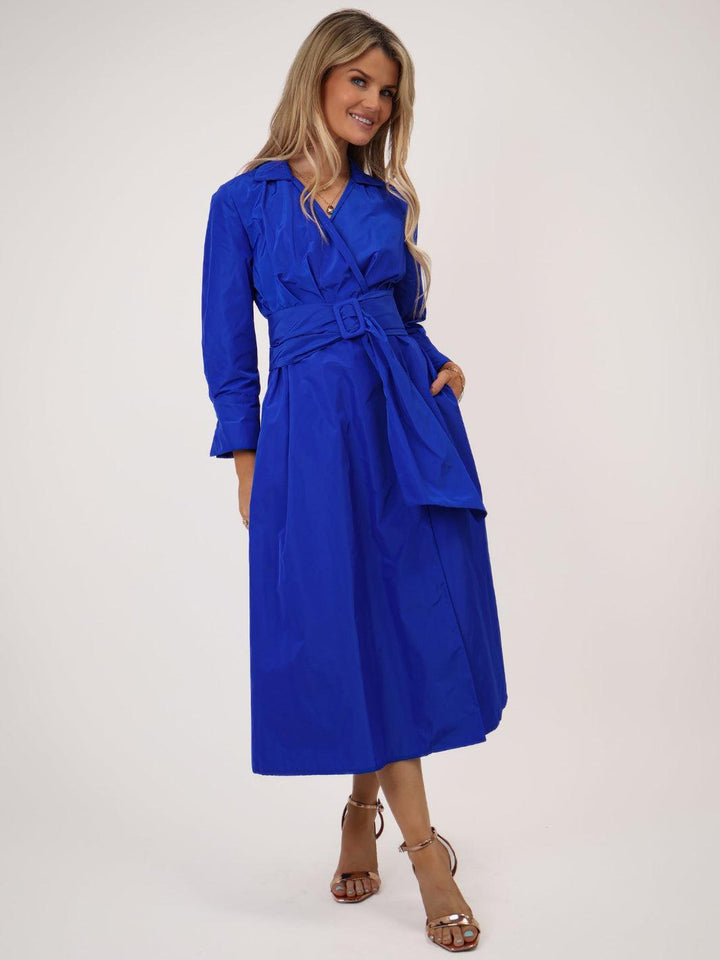 Woman wearing a blue dress with a belt on a white background