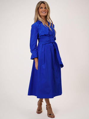 Woman wearing a blue dress with a belt on a white background