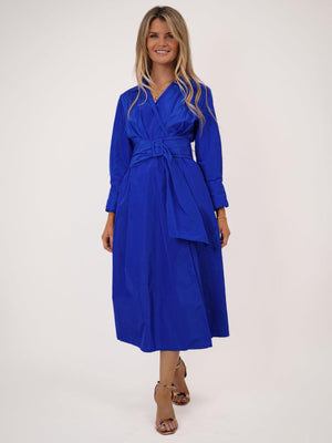 Woman wearing a blue dress with a belt on a white background