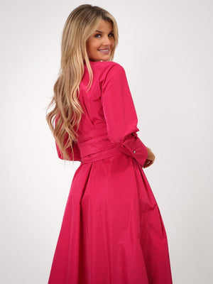 Woman wearing a bright pink dress against a white background