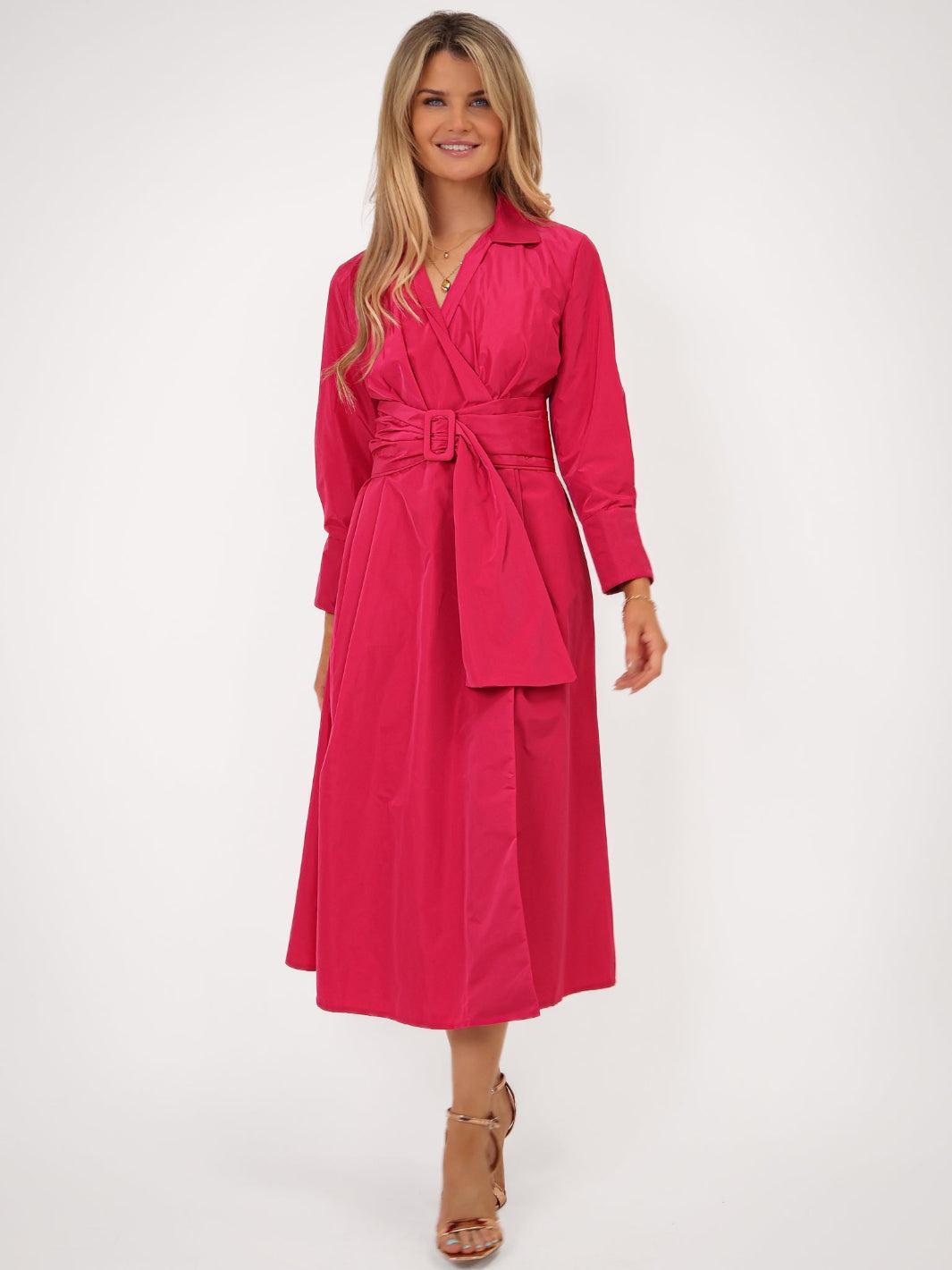 Woman wearing a pink dress with a belt on a white background