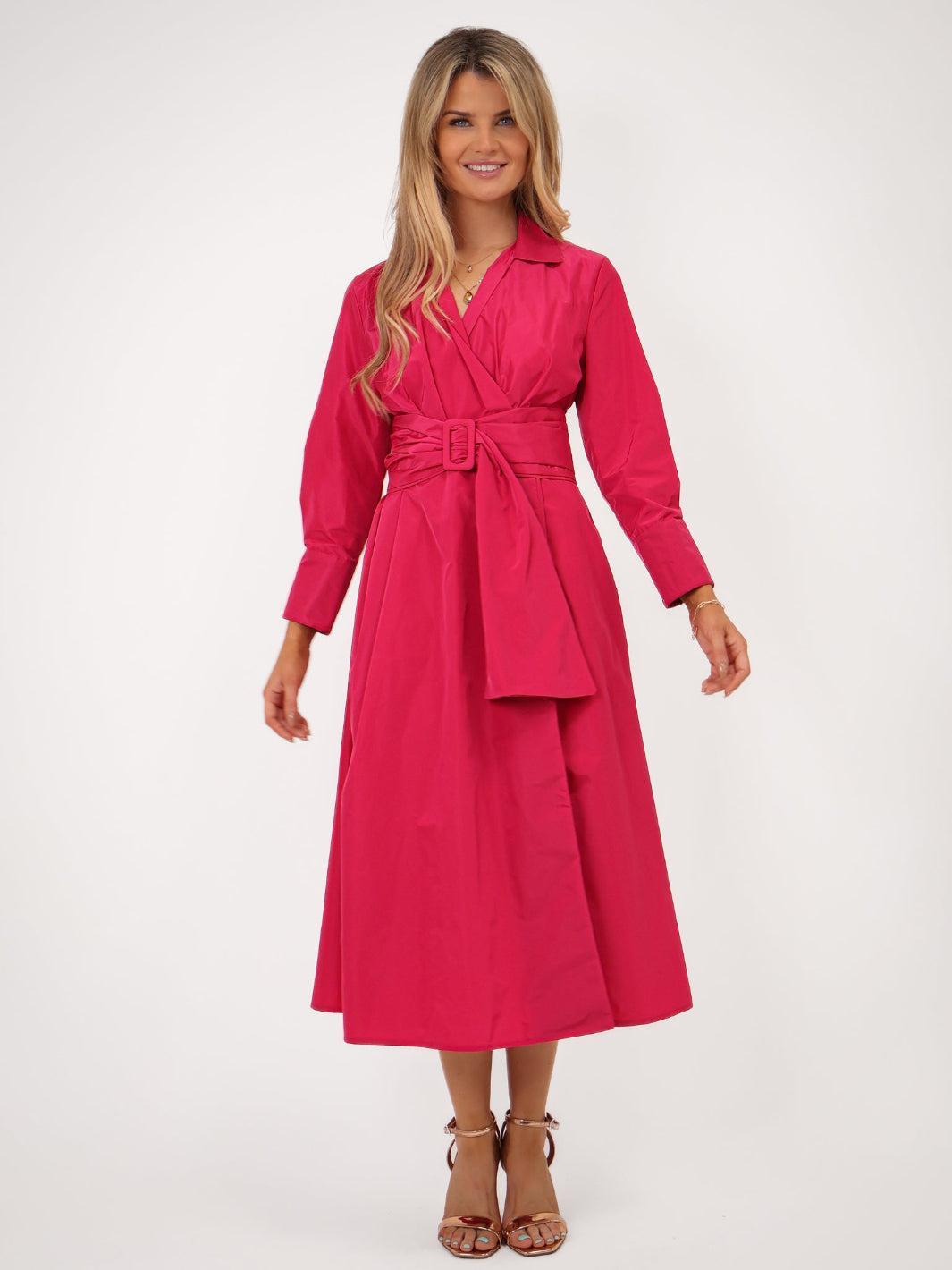 Woman wearing a pink dress with a belt on a white background