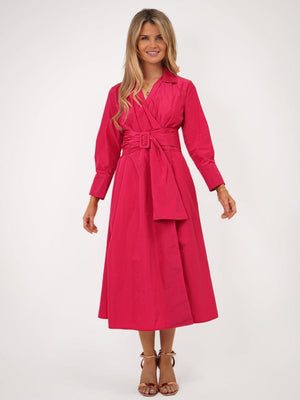 Woman wearing a pink dress with a belt on a white background