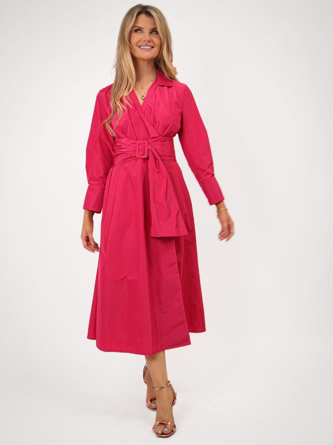 Woman wearing a pink dress with a belt on a white background