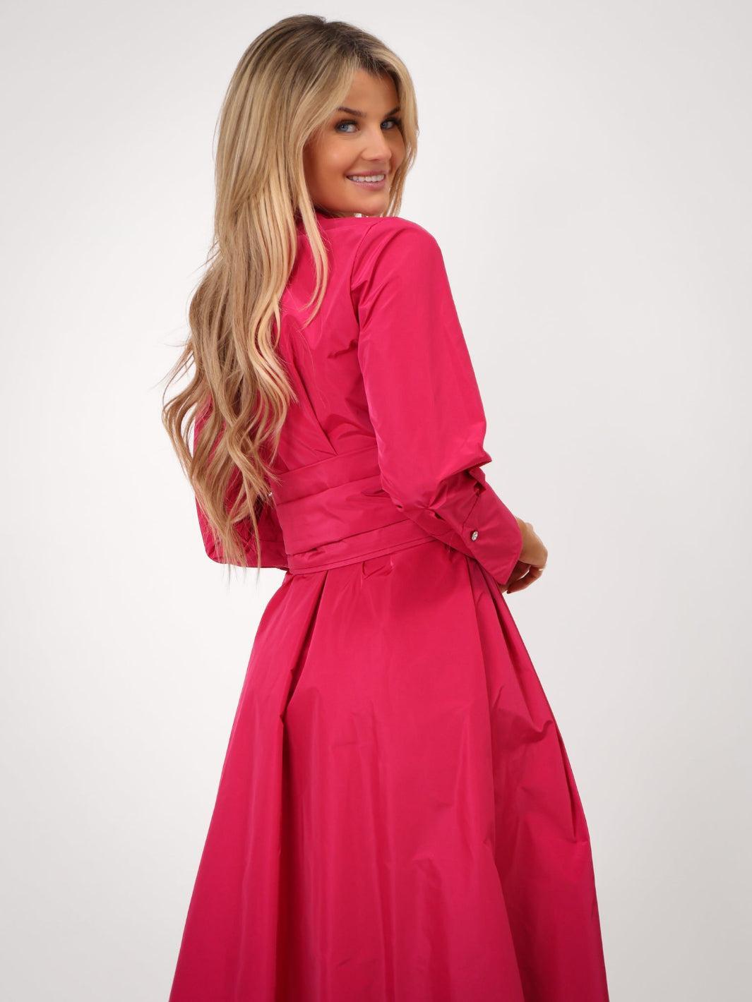 Woman wearing a bright pink dress against a white background