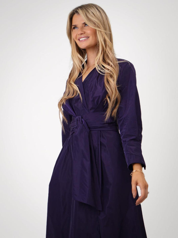Woman wearing a purple dress against a white background