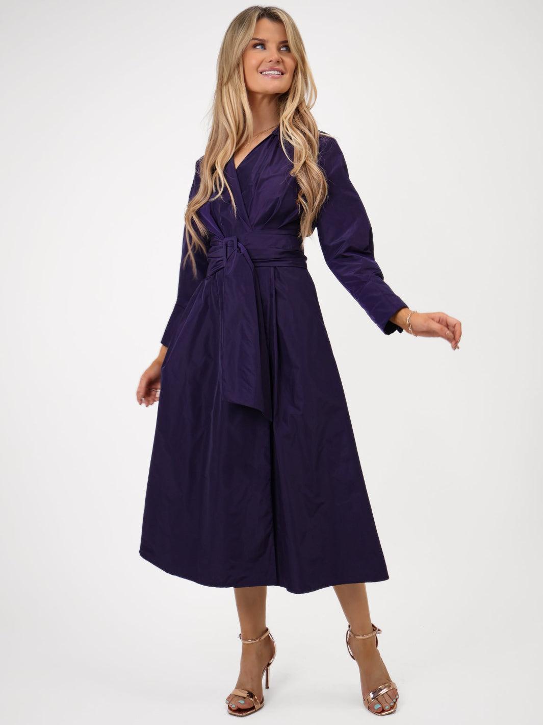Woman wearing a purple wrap dress on a white background