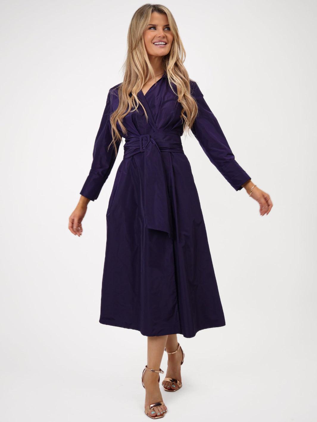 Woman wearing a purple wrap dress on a white background
