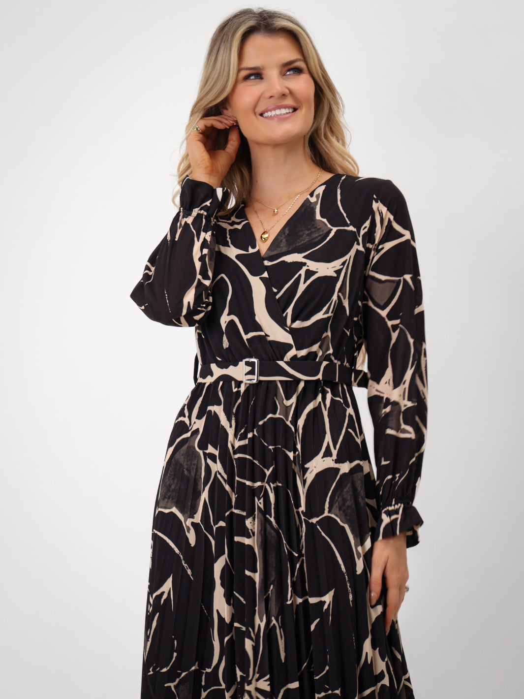 Woman wearing a black and beige patterned dress on a white background