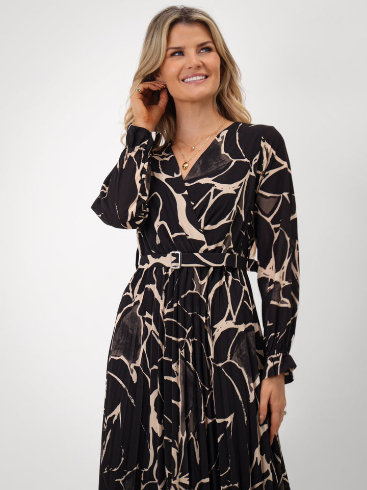 Woman wearing a black and beige patterned dress on a white background
