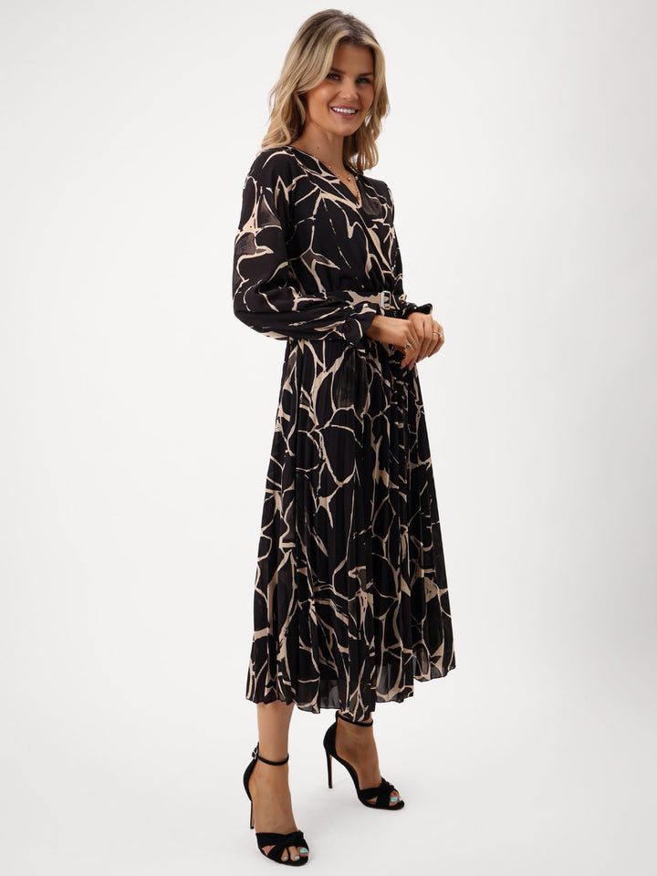 Woman wearing a black patterned dress on a white background