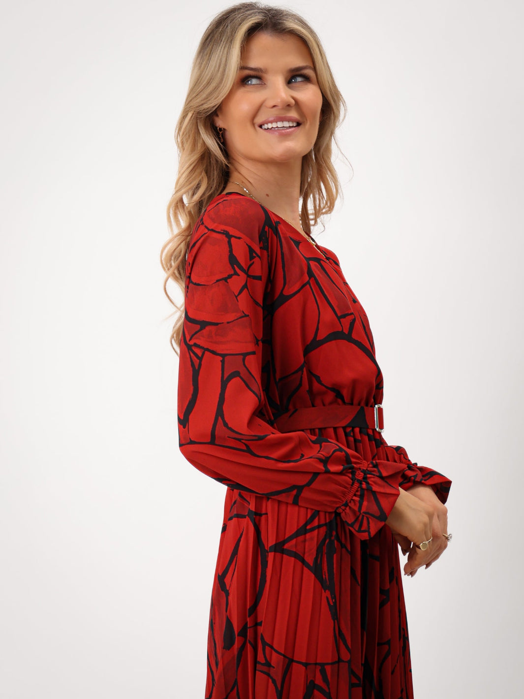 Woman wearing a red dress with black pattern on a white background