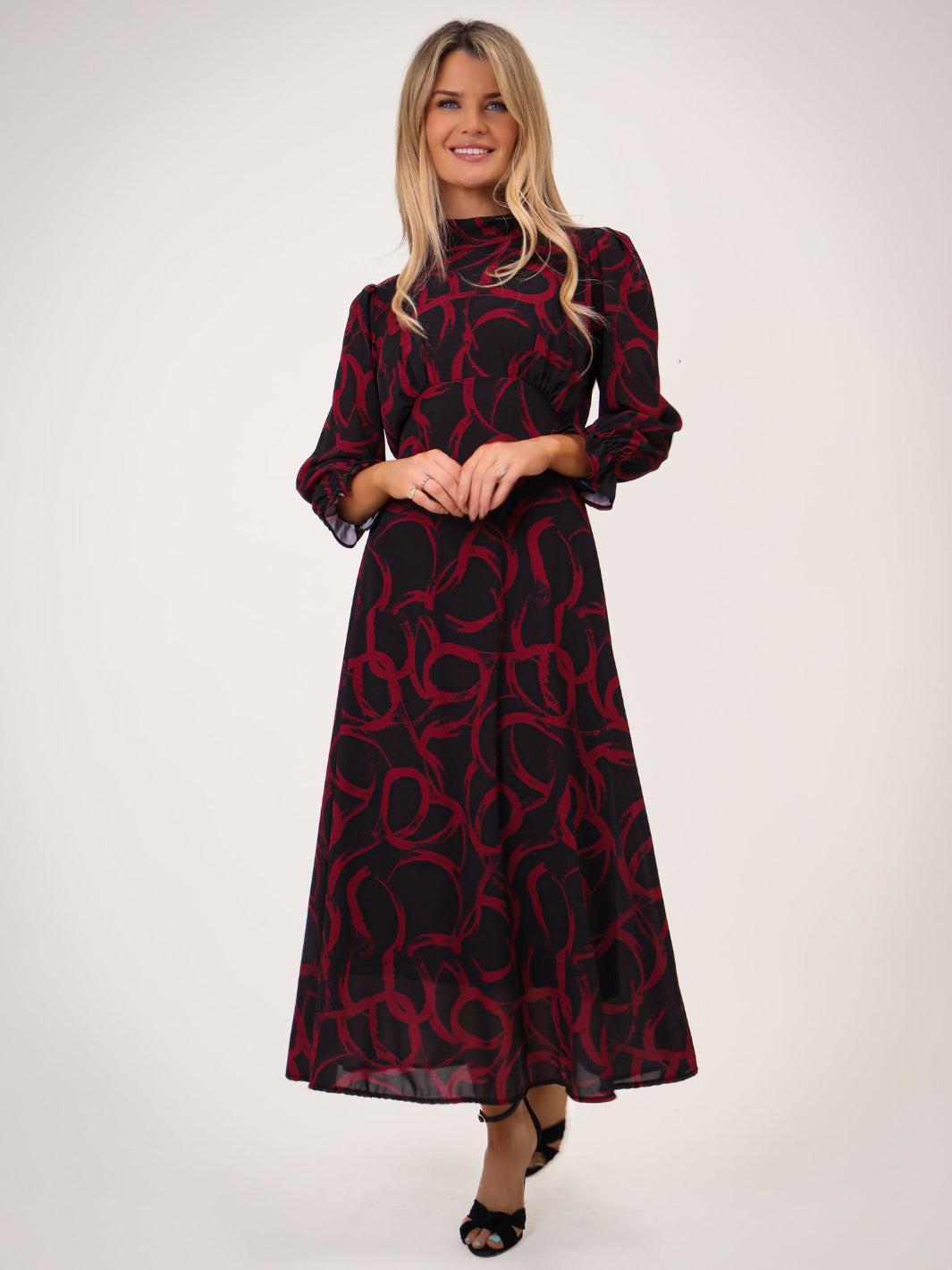 Woman wearing a red and black patterned dress on a white background