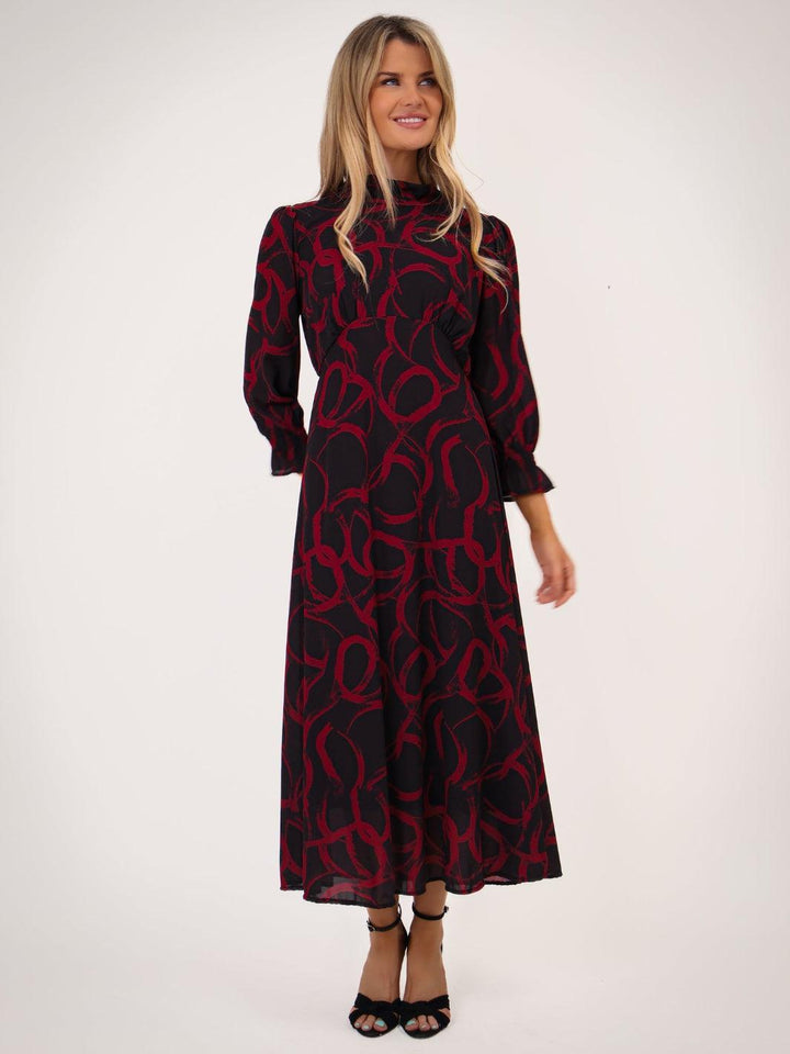 Woman wearing a black and red patterned dress on a white background