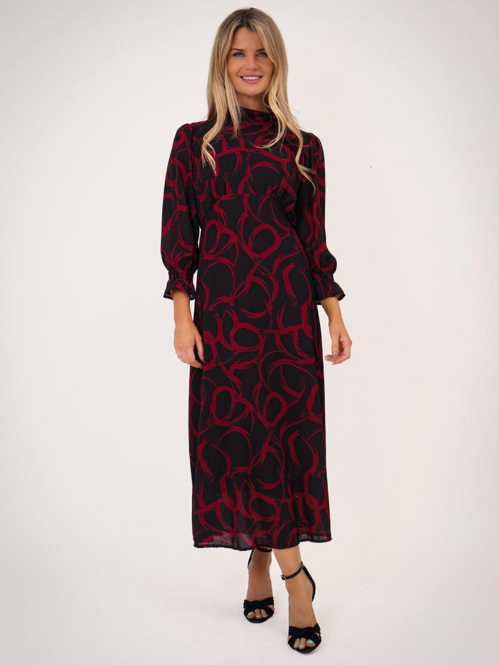 Woman wearing a black and red patterned dress on a white background