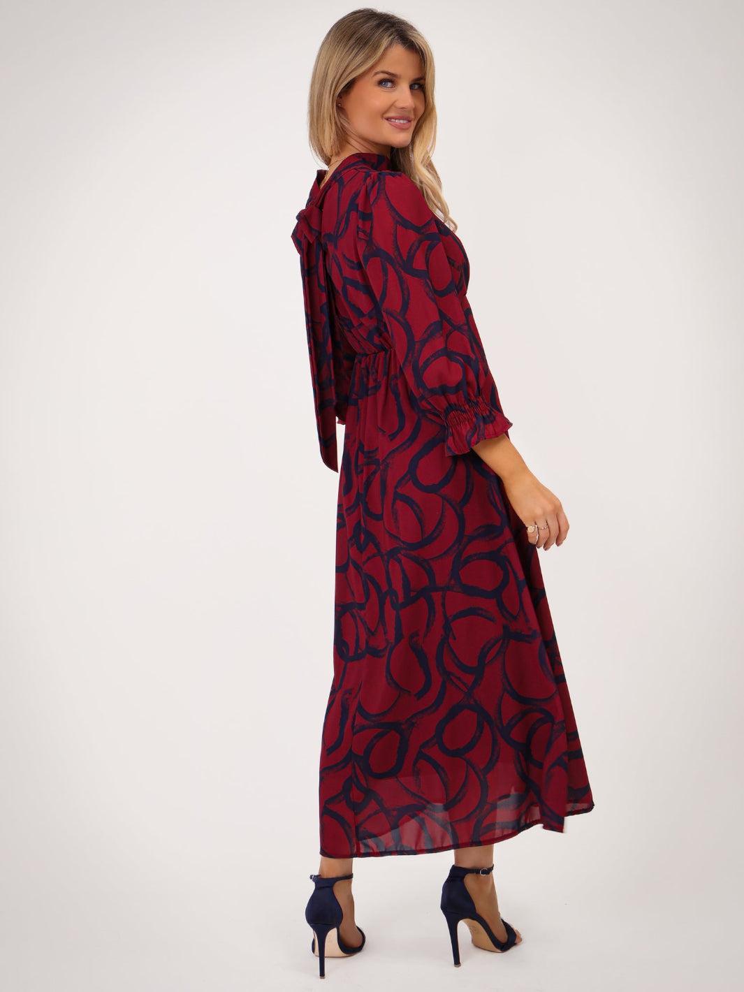 Woman wearing a red and black patterned dress on a white background