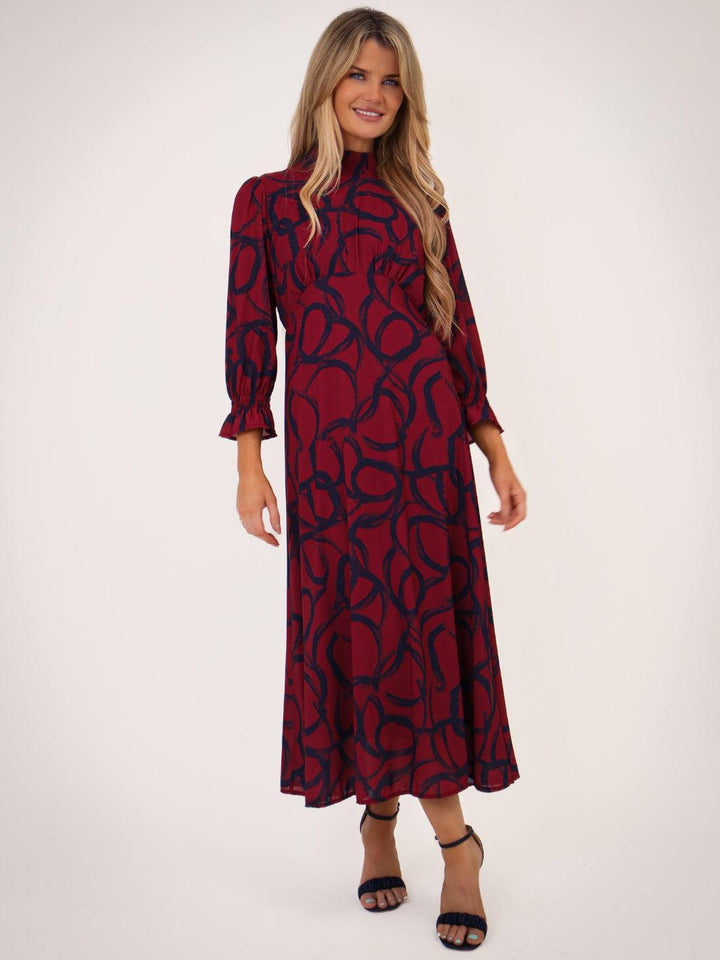 Woman wearing a red and black patterned dress on a white background