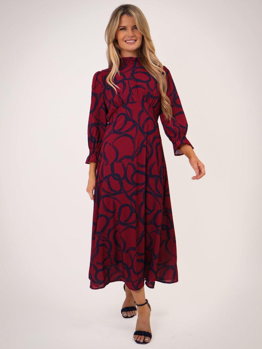 Woman wearing a red and black patterned dress on a white background