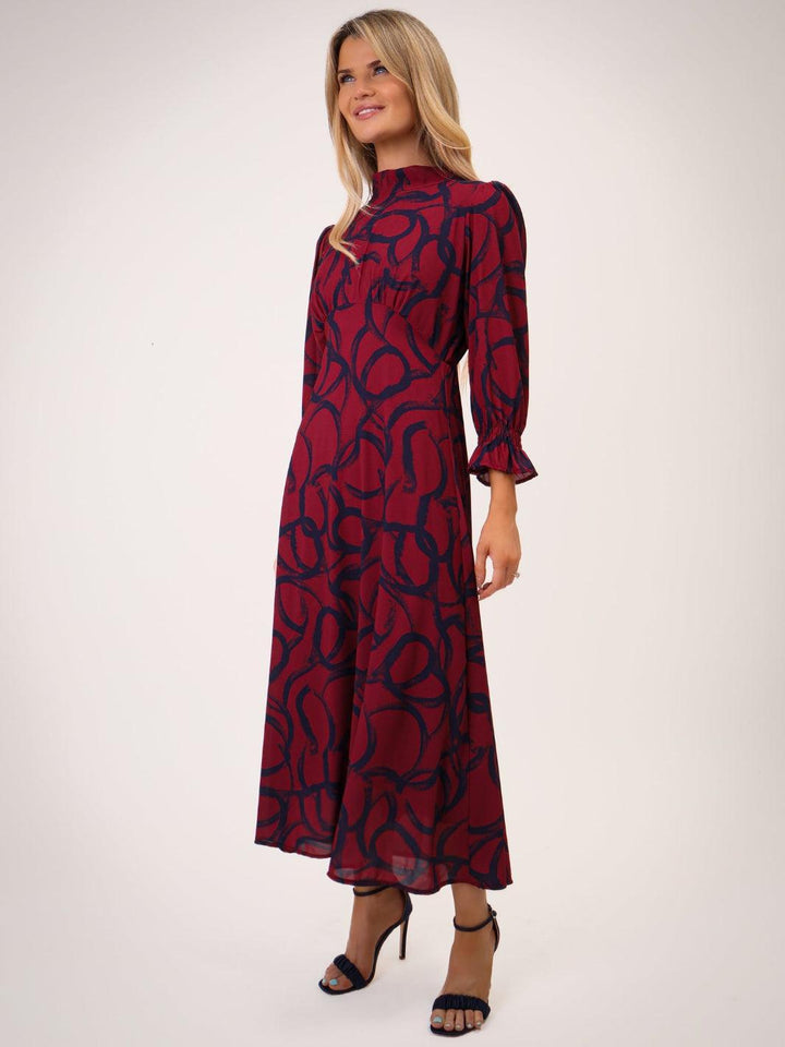 Woman wearing a red and black patterned dress on a white background
