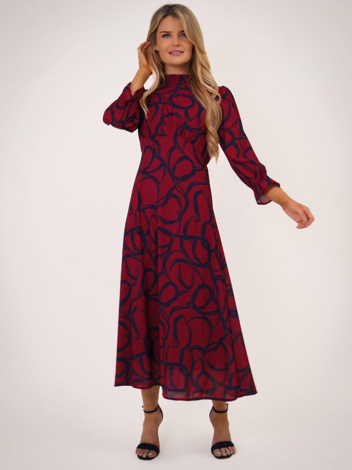 Woman wearing a red and black patterned dress on a white background