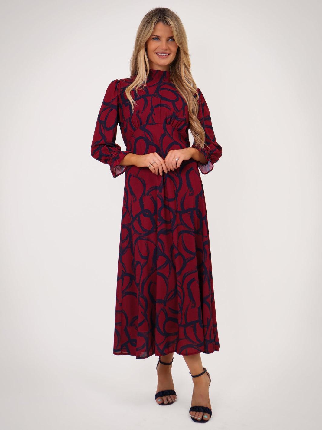 Woman wearing a red patterned dress on a white background
