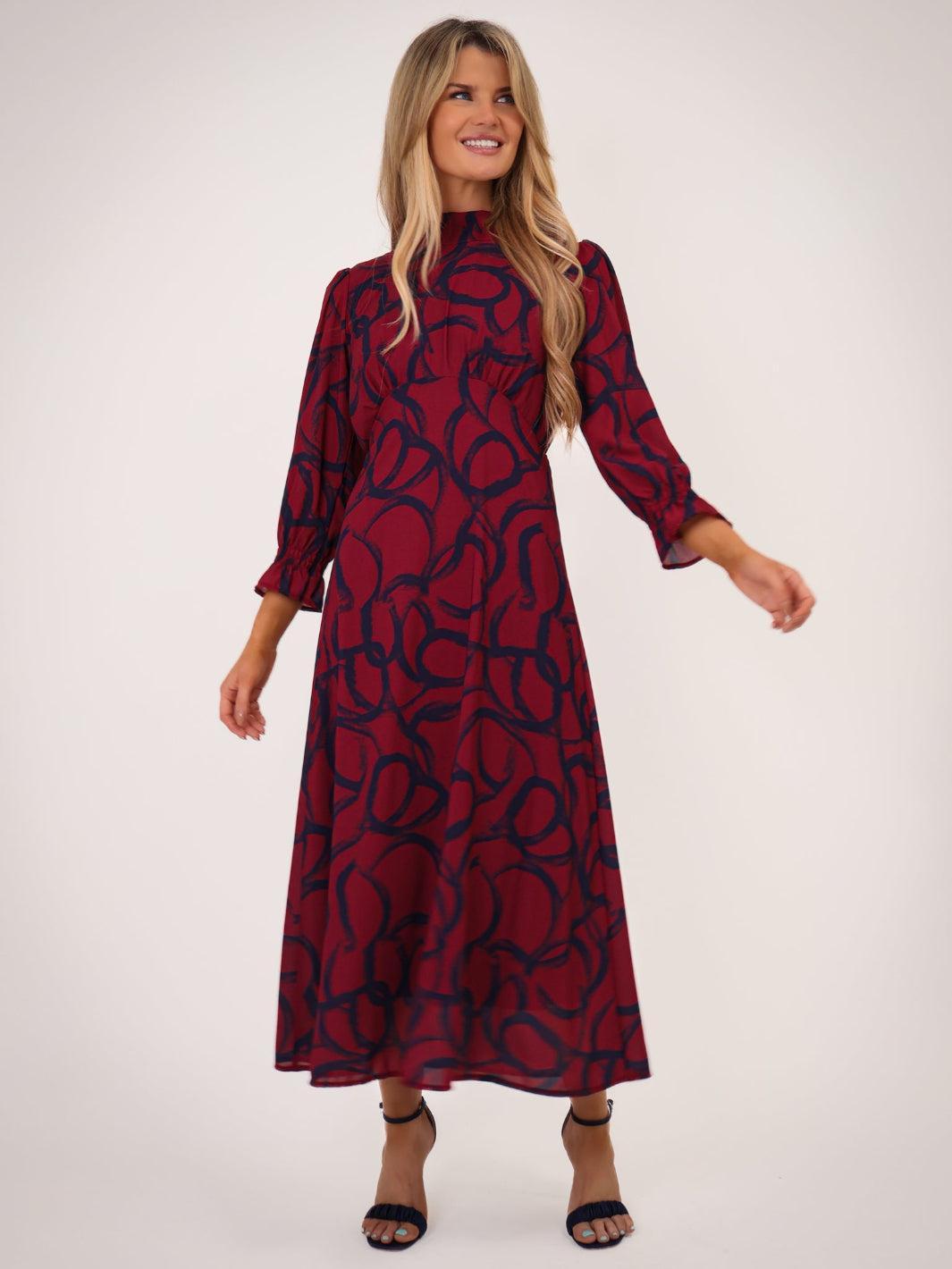 Woman wearing a red dress with black pattern on a white background