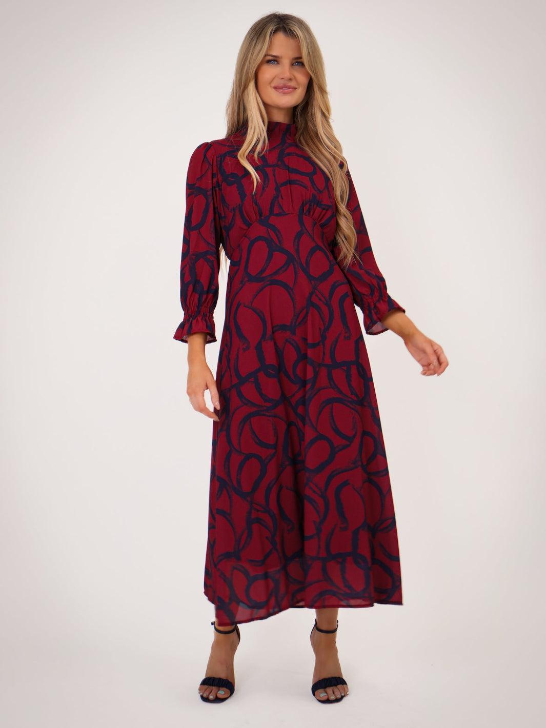 Woman wearing a red dress with black pattern on a white background