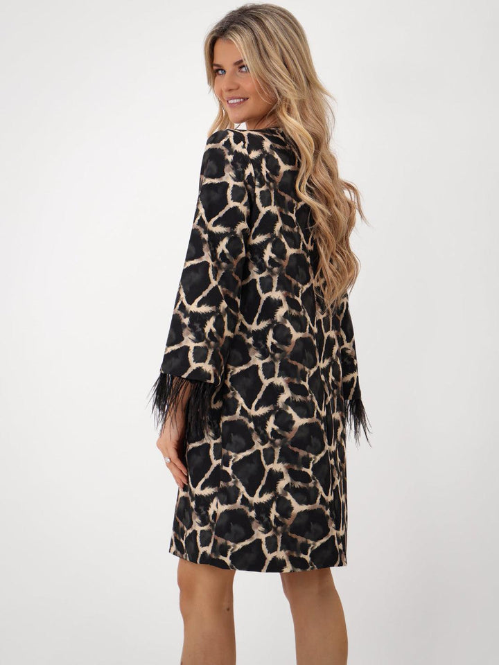 Woman wearing a leopard print dress against a white background