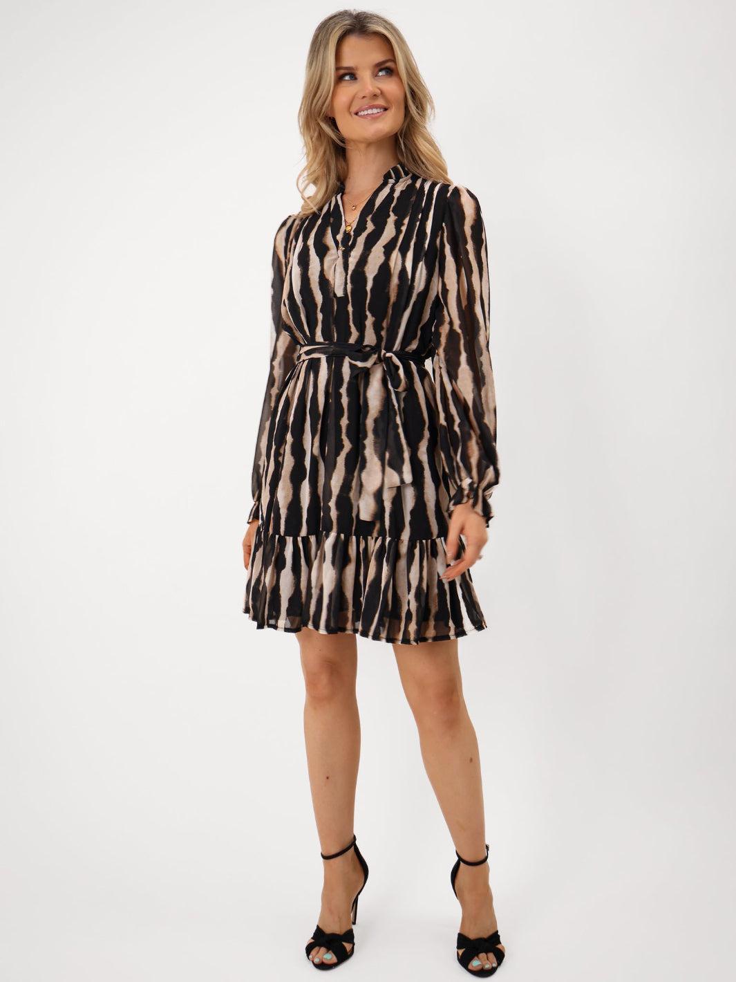 Woman wearing a patterned dress on a white background