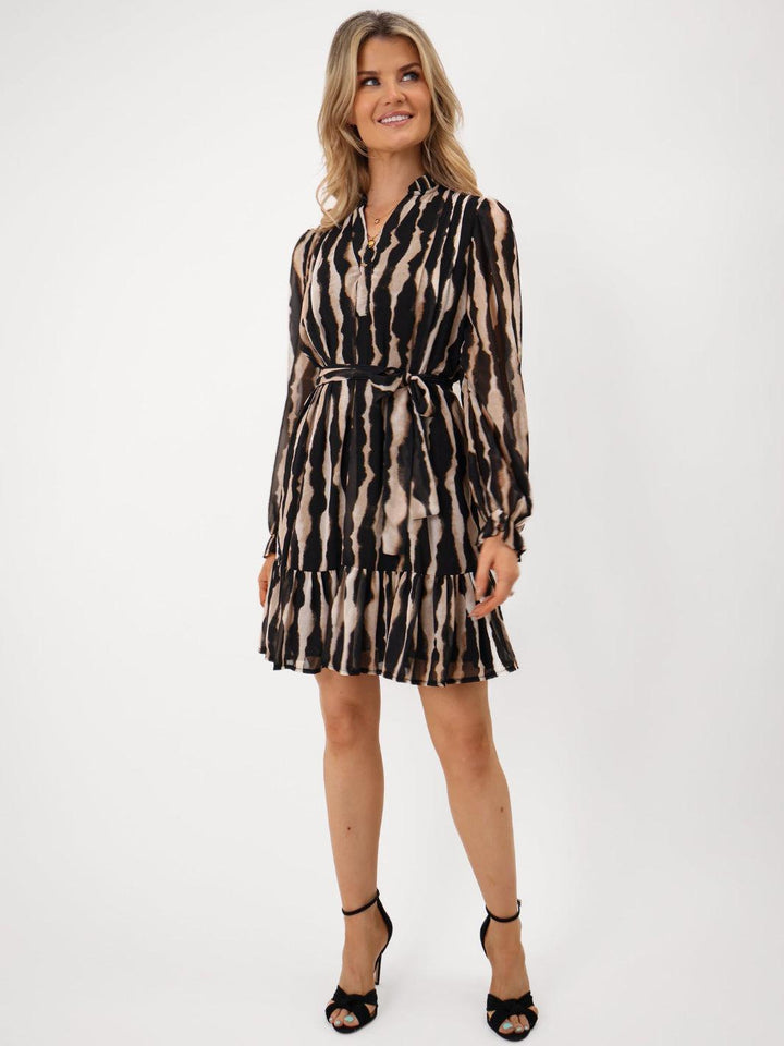 Woman wearing a patterned dress on a white background