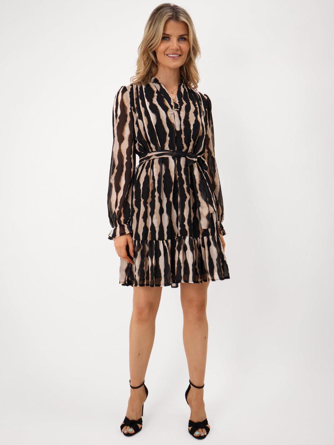 Woman wearing a patterned dress on a white background