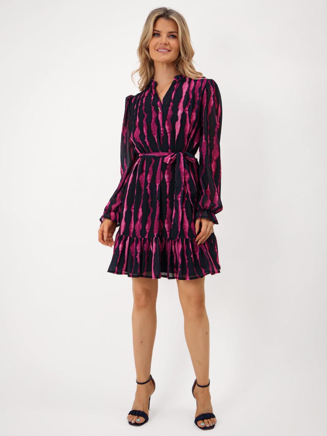 Woman wearing a black and pink patterned dress on a white background