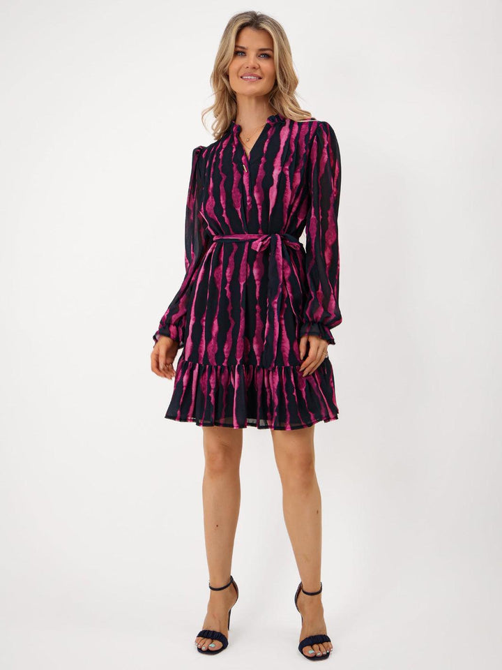 Woman wearing a black and pink patterned dress on a white background