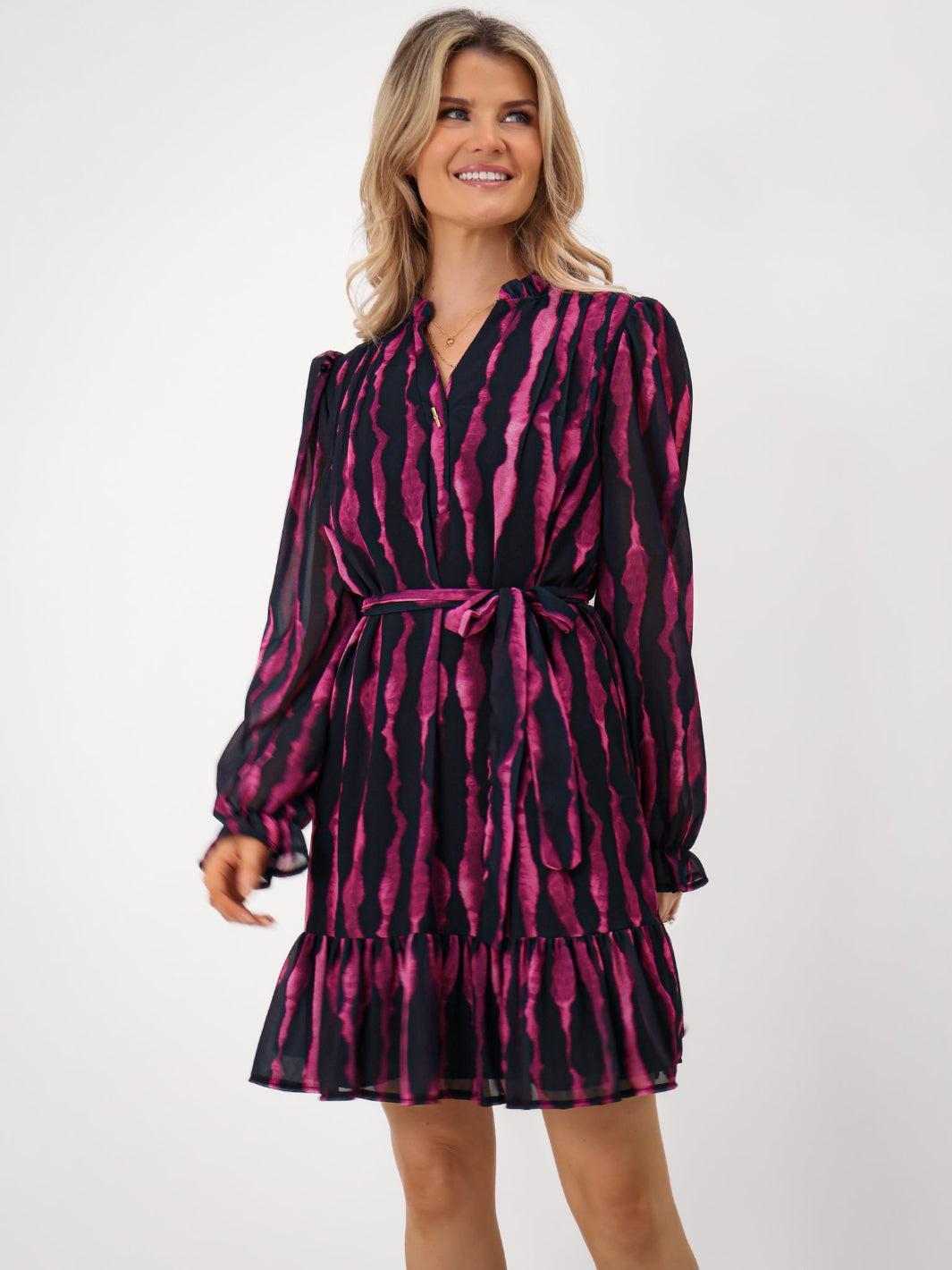 Woman wearing a black and pink patterned dress on a white background