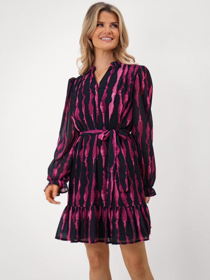 Woman wearing a black and pink patterned dress on a white background