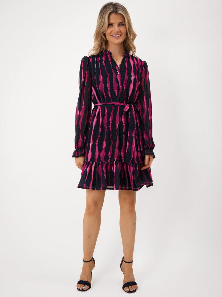 Woman wearing a black and pink patterned dress on a white background
