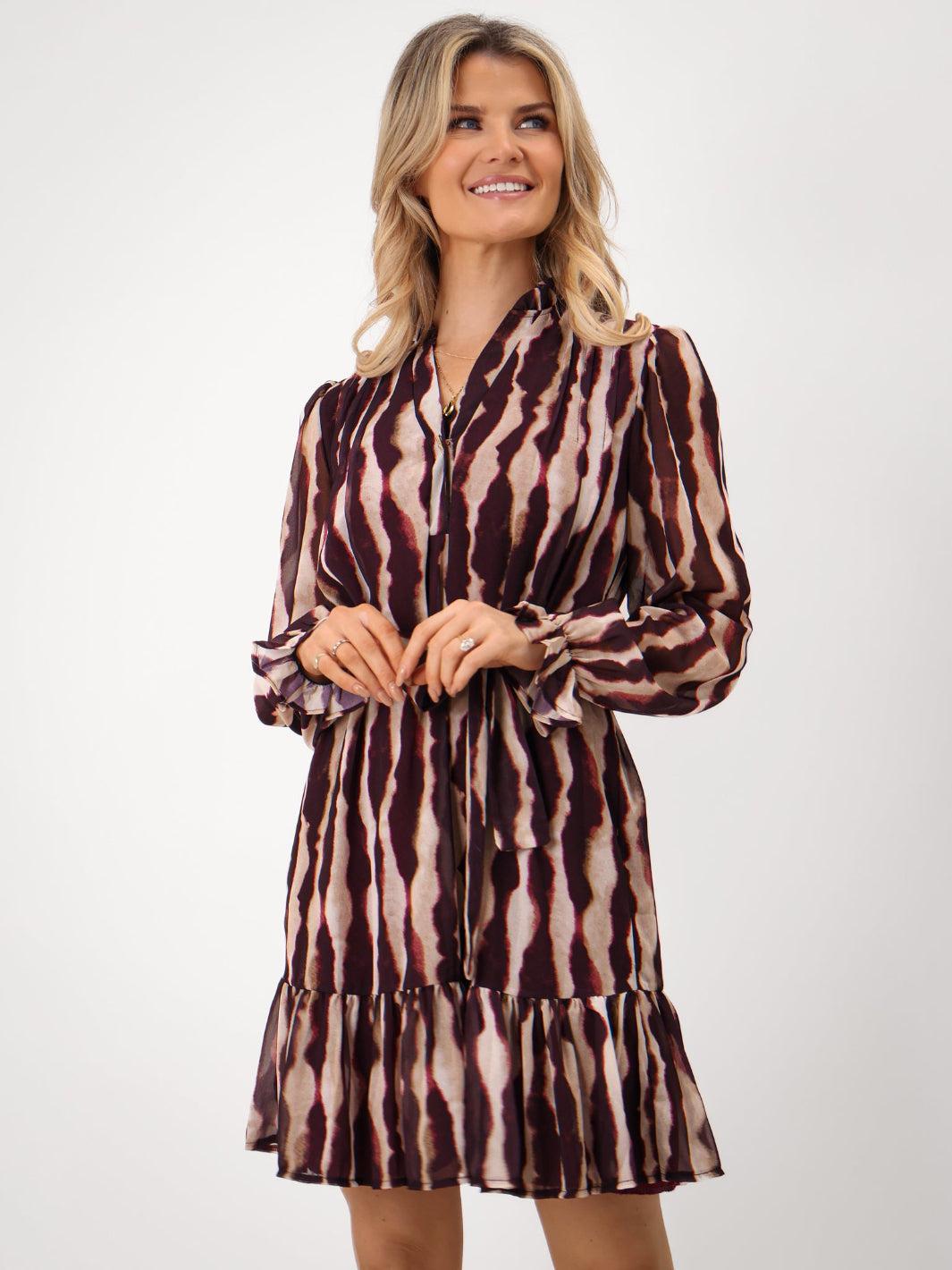 Woman wearing a patterned dress on a white background