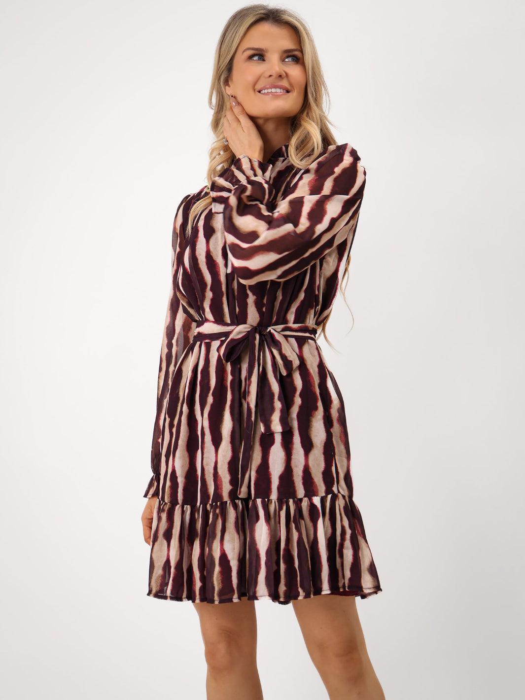 Woman wearing a brown and pink patterned dress on a white background