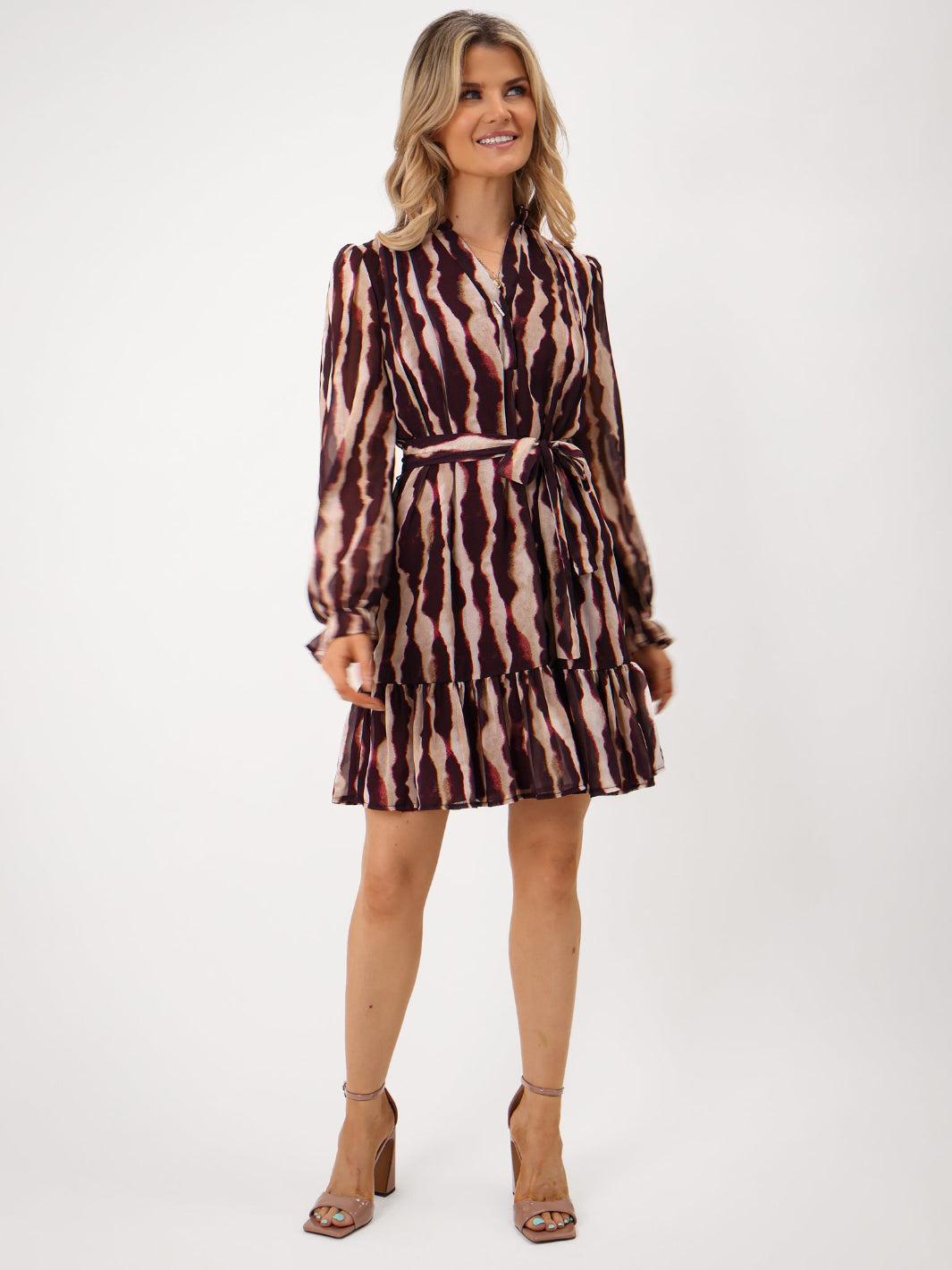 Woman wearing a patterned dress on a white background