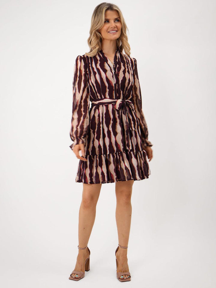 Woman wearing a patterned dress on a white background