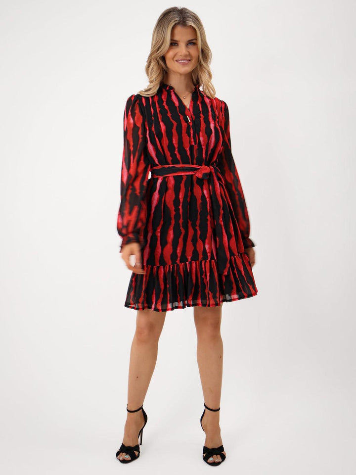 Woman wearing a red and black patterned dress on a white background