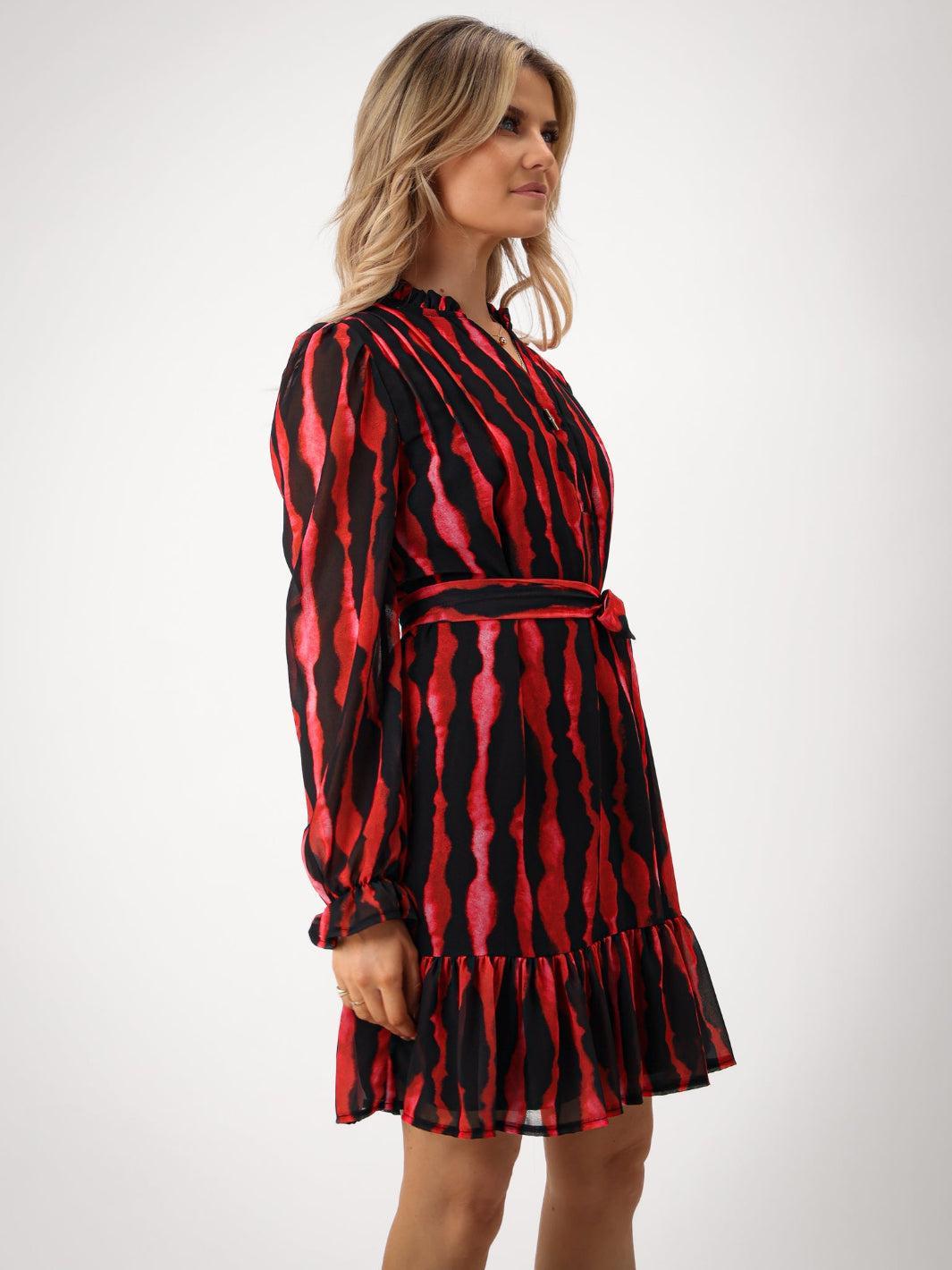 Woman wearing a red and black patterned dress on a white background