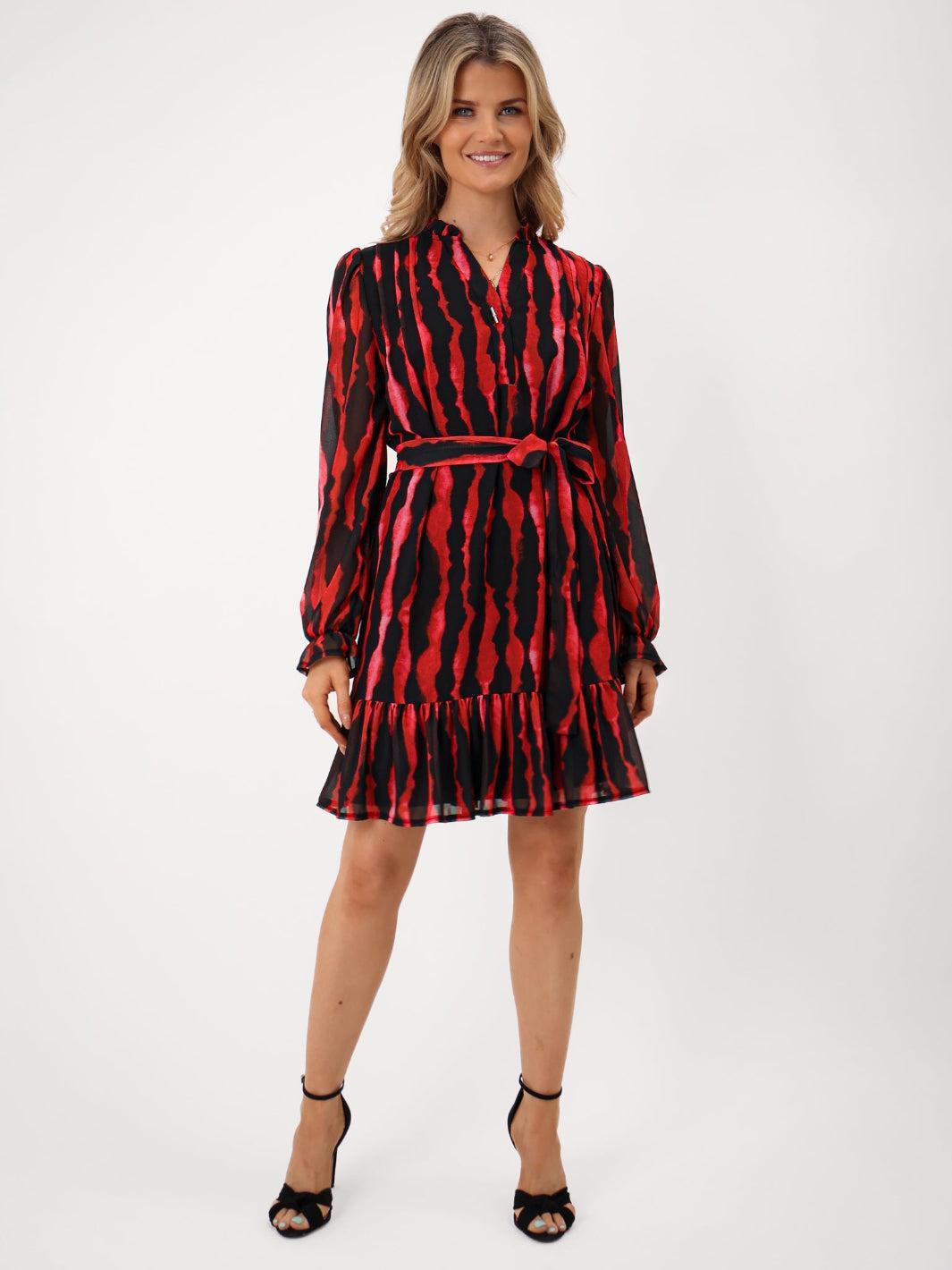 Woman wearing a red and black patterned dress on a white background